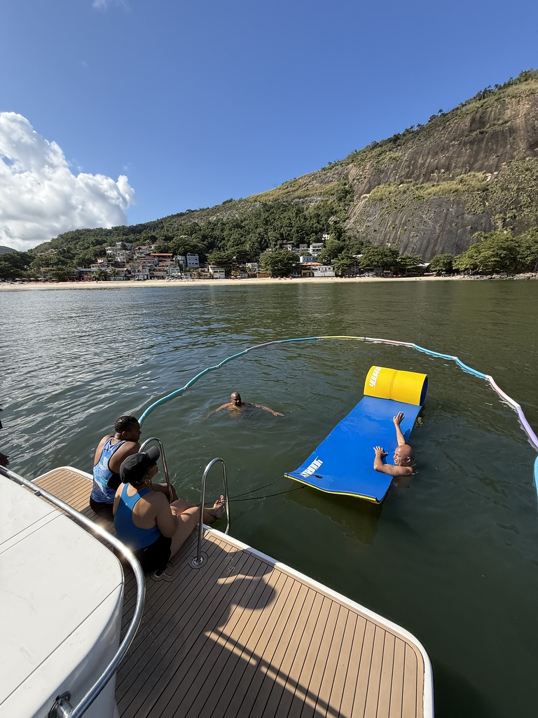 Travelers swimming at an anchored stop along the Rio coastline