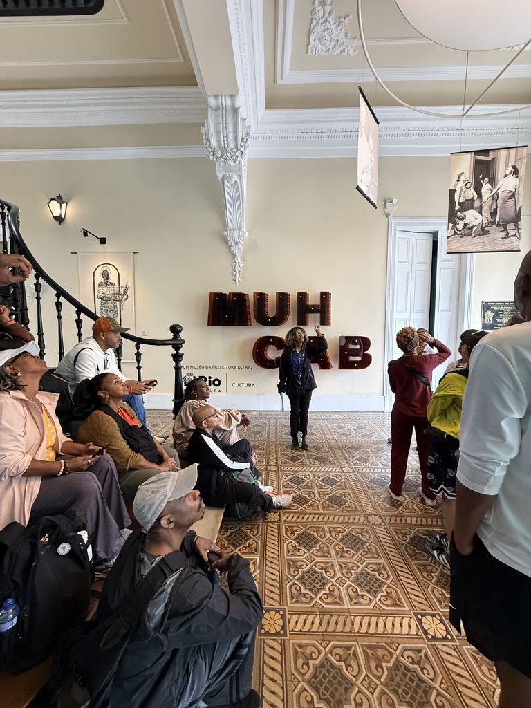 The guide speaking with travelers gathered inside MUHCAB