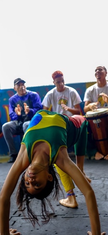 A capoeira performer mid-movement during a roda