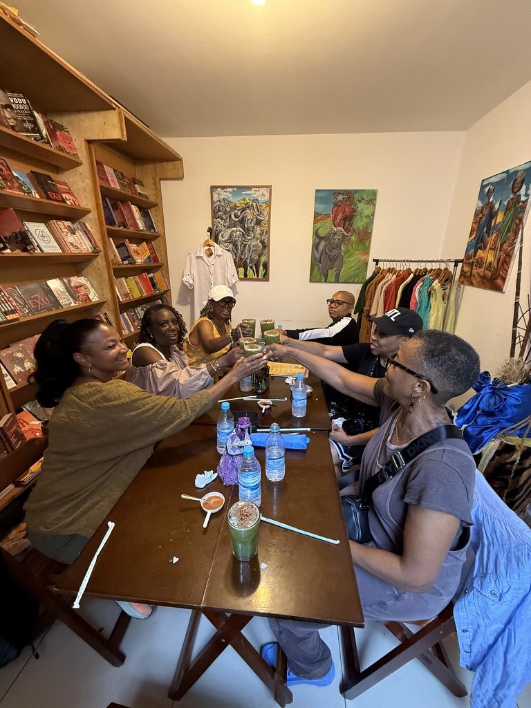 Travelers raising their glasses around a shared table over Afro-Brazilian lunch