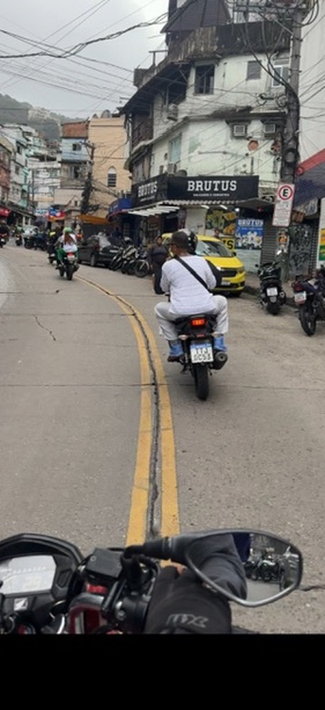 Riding into the community by moto-taxi along a busy street